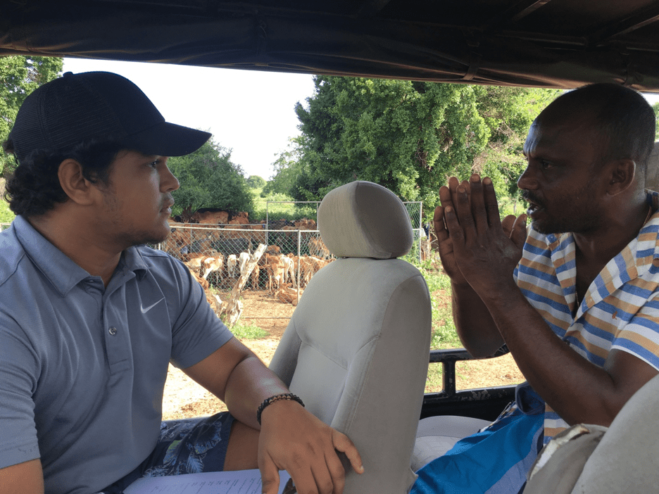 Social surveys being conducted with local cattle herders (right). In the background is a steel pen, that some herders in the area have been given in order to better protect their cattle from leopard depredation. Image