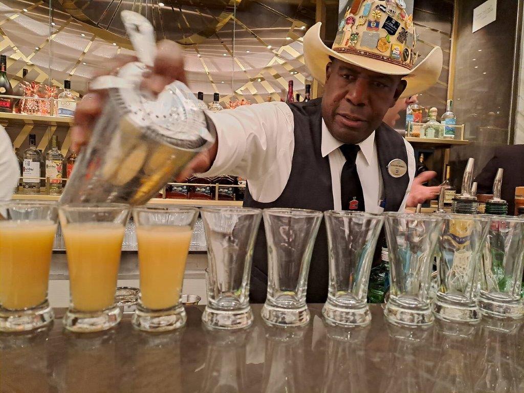 Bartender Clarence Bennett racks up drinks in NCL Prima’s Metropolitan “sustainability bar”. norwegein prima barman drinks