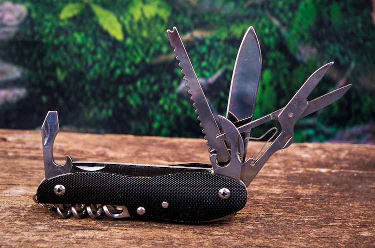 A swiss army knife placed upon oak.