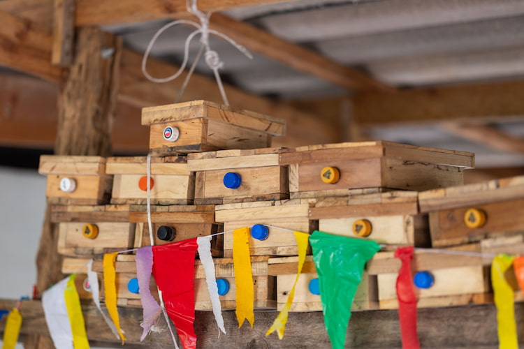 Small wooden boxes housing bee colonies, created as part of the Bee The Change initiative.